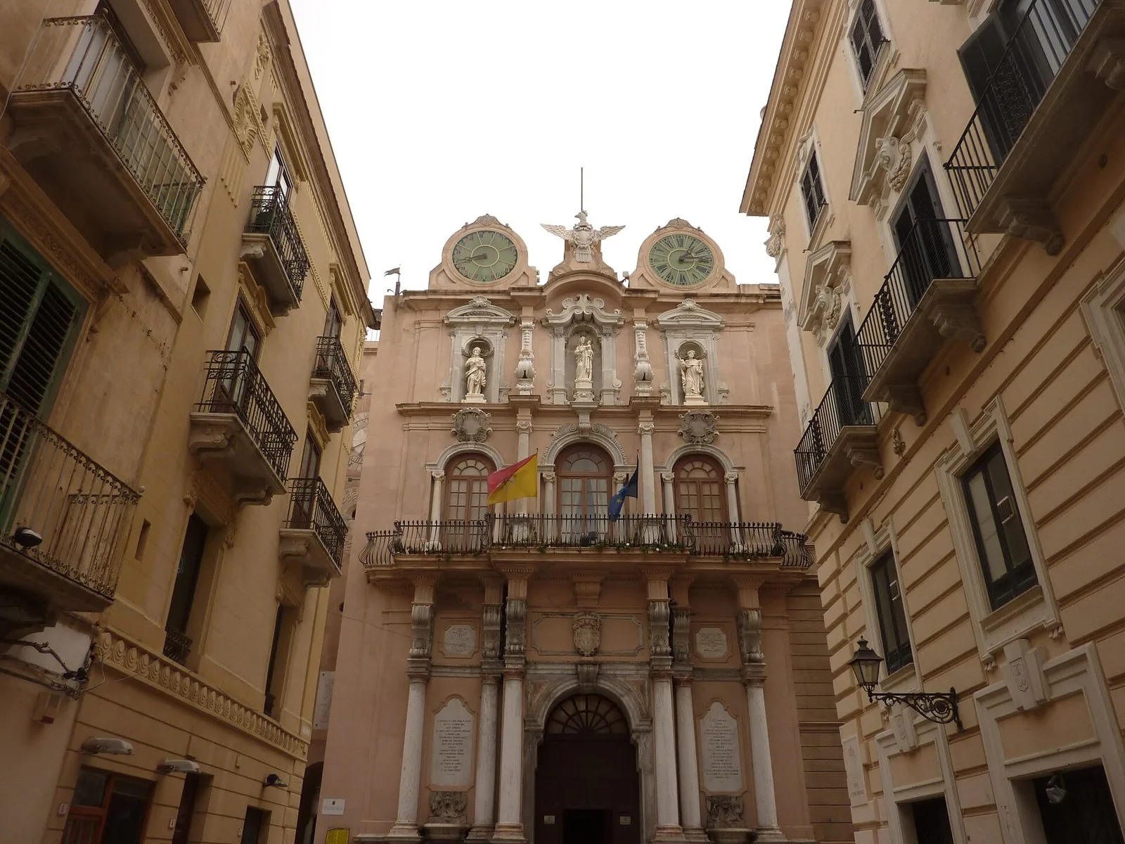 Facciata barocca del Palazzo Senatorio di Trapani con i due orologi e le statue