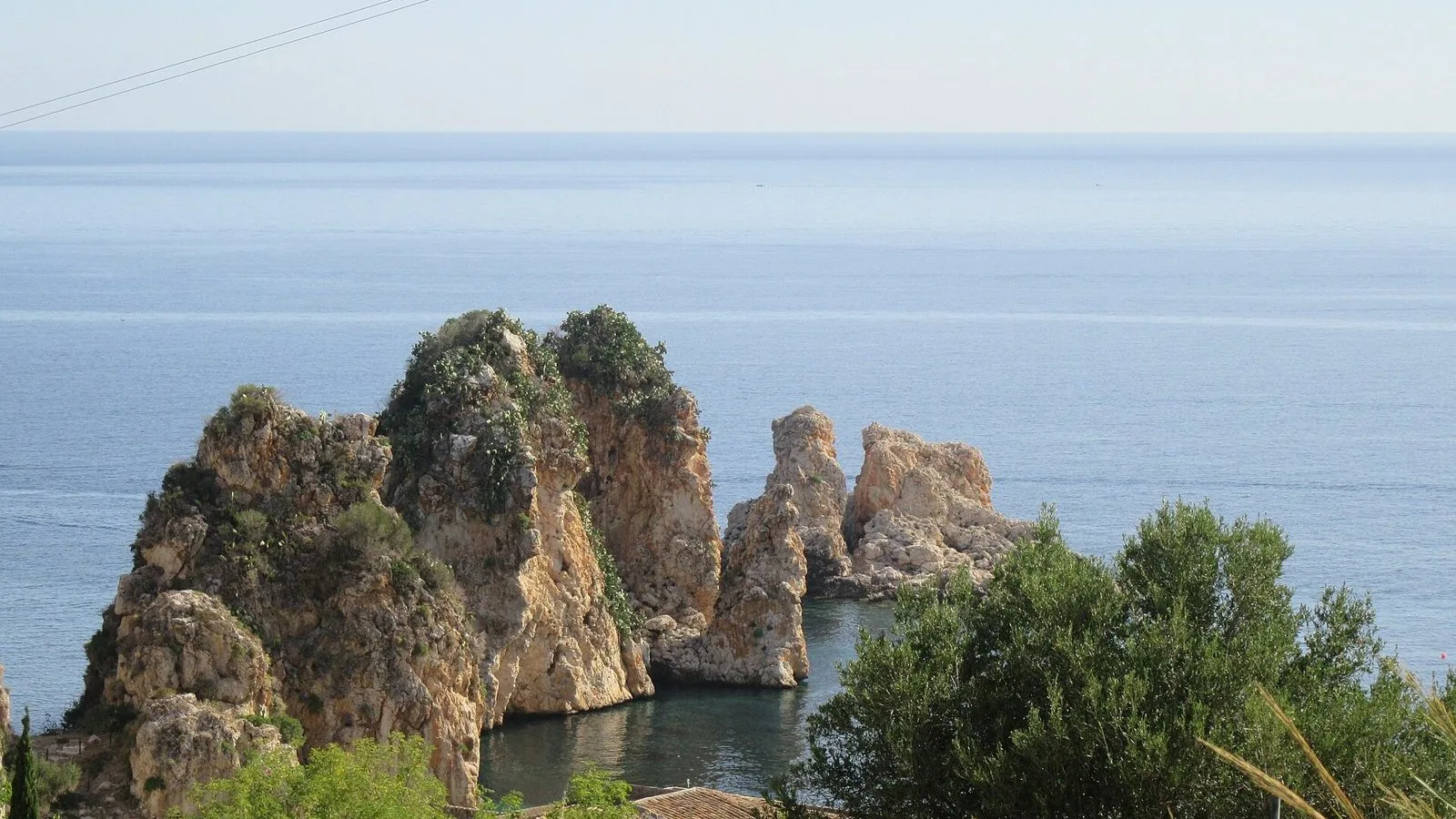 I faraglioni di Scopello davanti alla tonnara, con il mare blu sullo sfondo